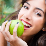 Portrait of a young woman's face eating an apple